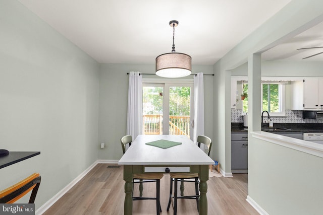 dining area featuring light wood-type flooring, baseboards, and a wealth of natural light
