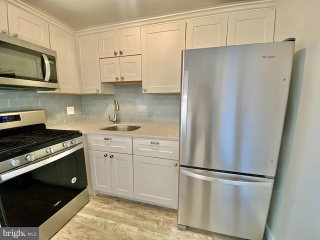 4901 Harbor Beach Blvd Unit P12, Brigantine, NJ 08203 - kitchen with white cabinets, appliances with stainless steel finishes, a sink, light wood-style flooring, and decorative backsplash