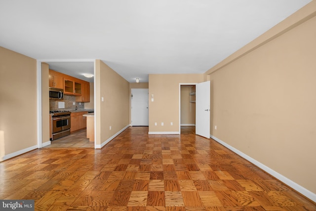 unfurnished living room with baseboards