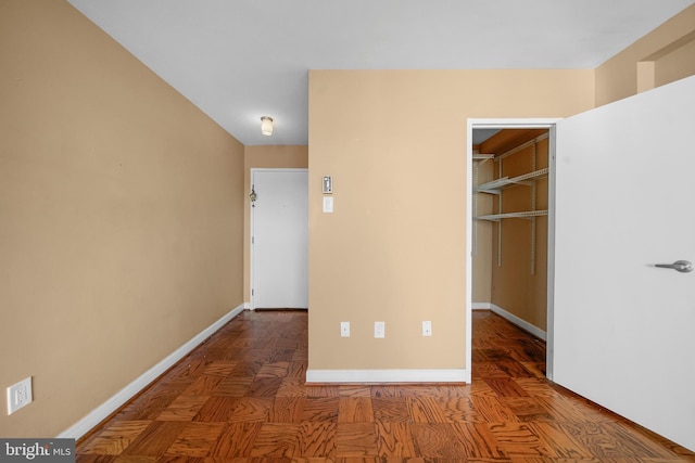 unfurnished bedroom featuring baseboards, a spacious closet, and a closet