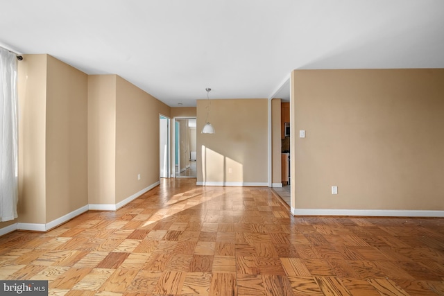 unfurnished room with baseboards