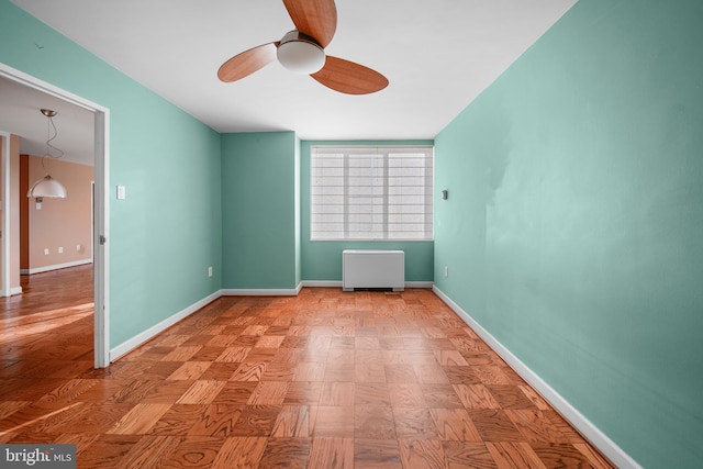 unfurnished room with a ceiling fan and baseboards