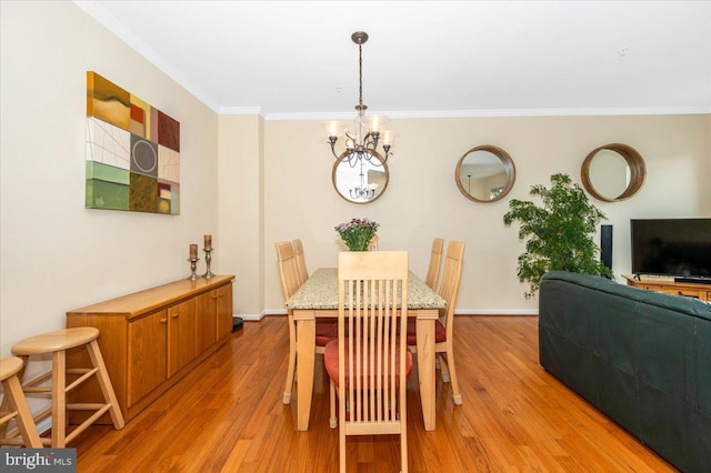 dining space featuring ornamental molding, a chandelier, light wood finished floors, and baseboards