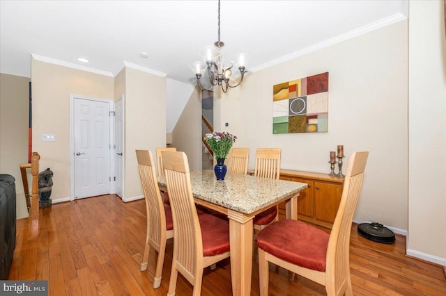 dining room with a chandelier, light wood-style flooring, ornamental molding, baseboards, and recessed lighting