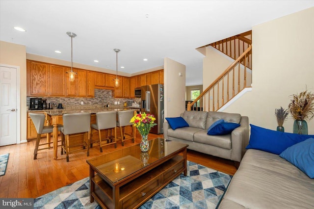 living room featuring light wood-style floors, stairway, and recessed lighting