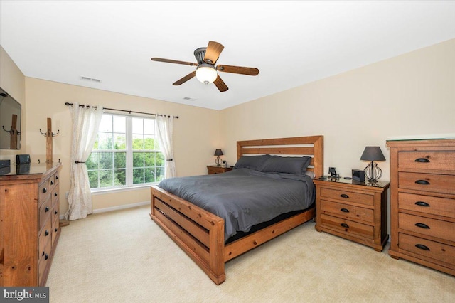bedroom with light carpet, a ceiling fan, and baseboards
