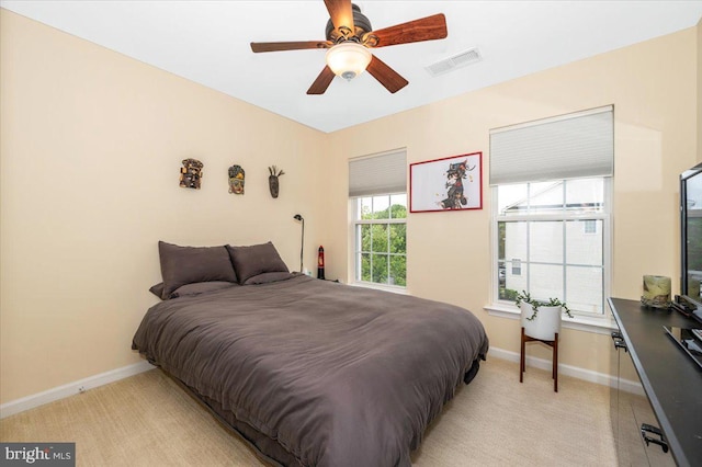 bedroom featuring baseboards, light colored carpet, and a ceiling fan