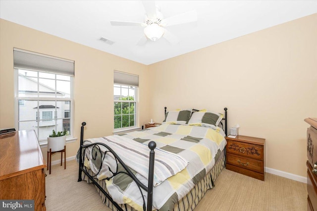 bedroom featuring baseboards, light carpet, and a ceiling fan