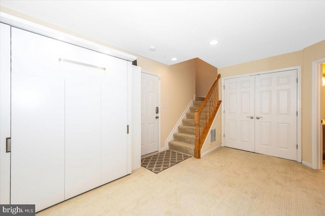 below grade area featuring stairway, light carpet, recessed lighting, and baseboards