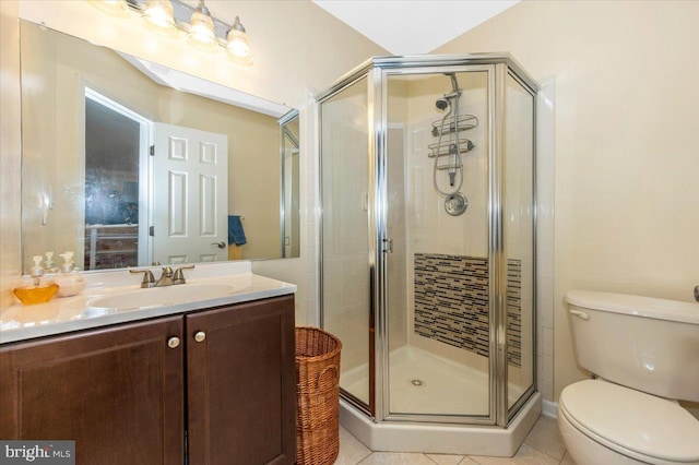 full bathroom featuring a stall shower, toilet, vanity, and tile patterned flooring