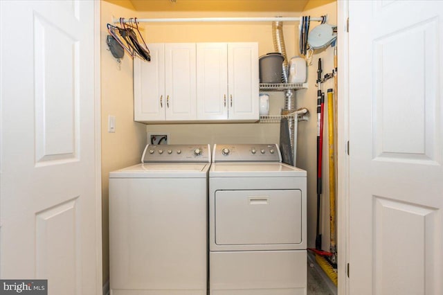 washroom with cabinet space and washer and dryer