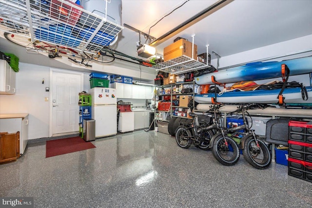 garage with freestanding refrigerator, washer and dryer, and a garage door opener