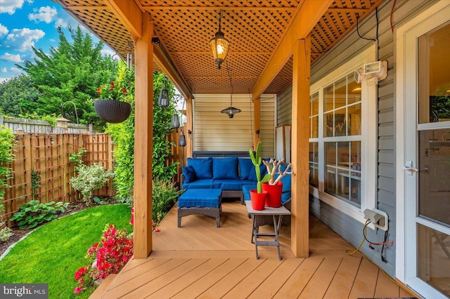 wooden terrace with an outdoor living space and fence