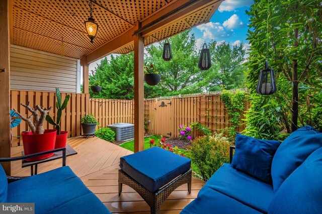 view of patio featuring a fenced backyard, a wooden deck, outdoor lounge area, and central AC unit