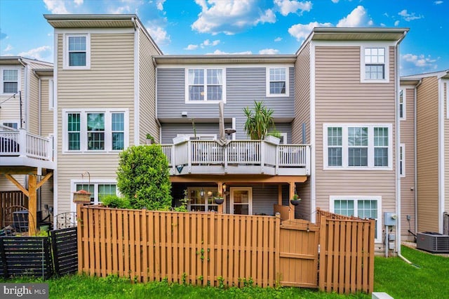 rear view of property with central AC unit and fence