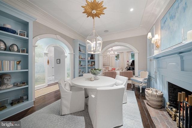 109 Duke St, Alexandria, VA 22314 - dining area with arched walkways, built in shelves, a chandelier, ornamental molding, and wood finished floors