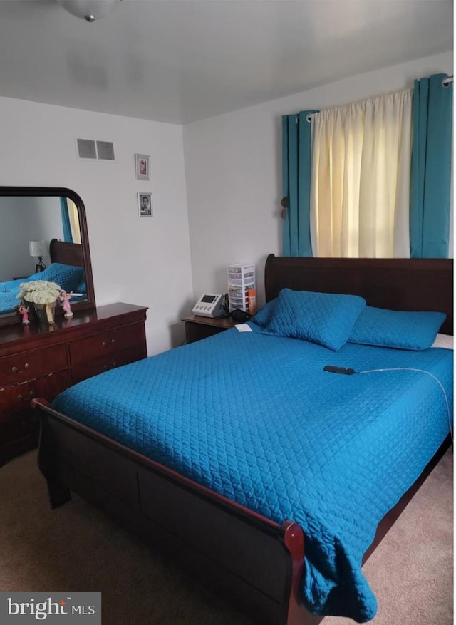 carpeted bedroom featuring visible vents