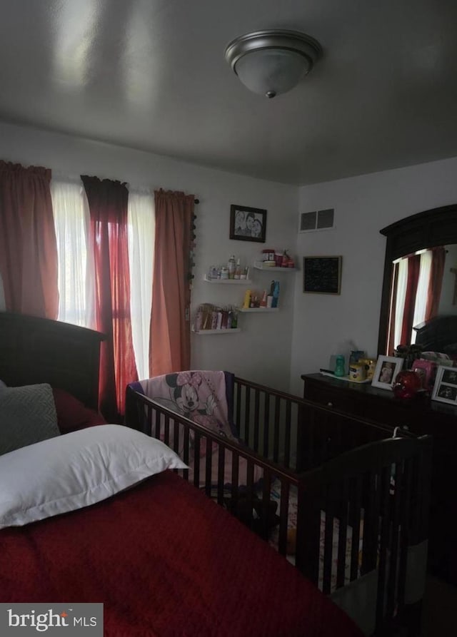 bedroom with visible vents and multiple windows