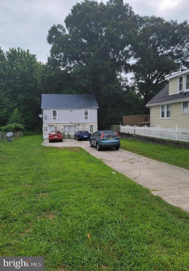 view of front of home featuring fence, driveway, and a front yard