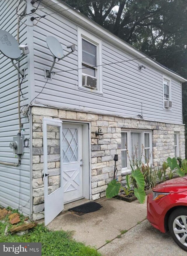 rear view of house featuring stone siding
