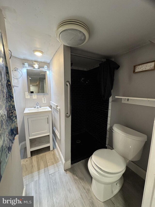 2117 Kearny St NE, Washington, DC 20018 - bathroom with wood finished floors, vanity, a stall shower, toilet, and baseboards