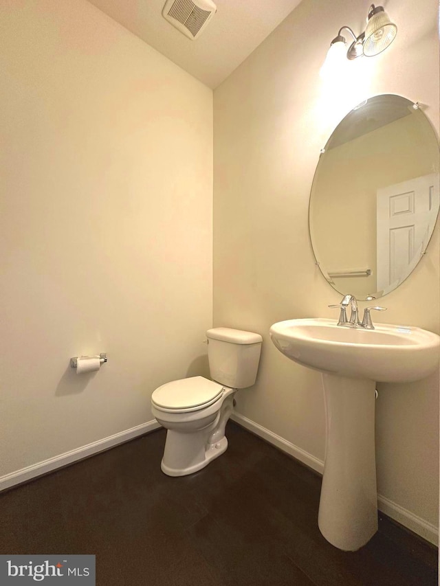 bathroom with toilet, baseboards, vaulted ceiling, and a sink
