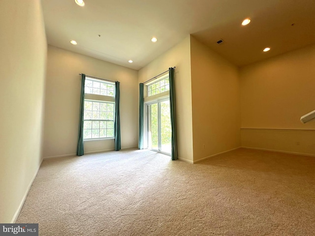 carpeted empty room featuring recessed lighting and baseboards