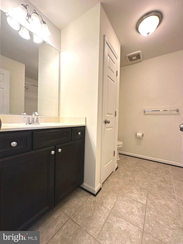 full bathroom featuring toilet, tile patterned floors, baseboards, and vanity