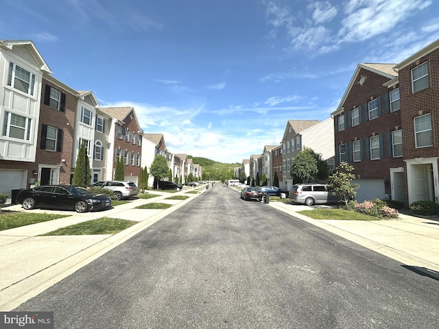 view of asphalt road featuring a residential view and sidewalks