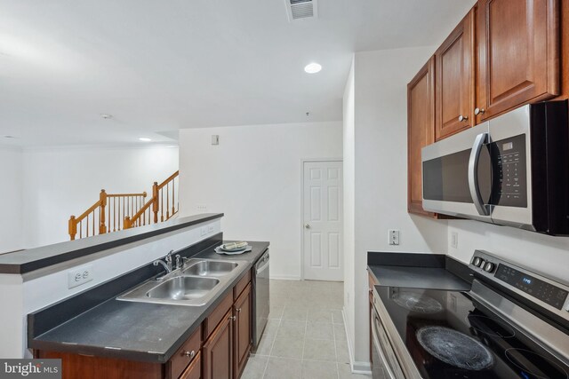 24764 Stone Station Ter, Aldie, VA 20105 - kitchen featuring stainless steel appliances, dark countertops, light tile patterned floors, a sink, and recessed lighting