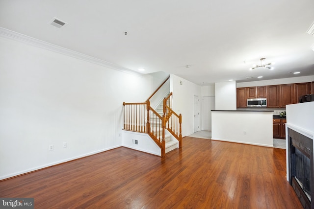 24764 Stone Station Ter, Aldie, VA 20105 - unfurnished living room featuring stairway, wood finished floors, baseboards, recessed lighting, and crown molding