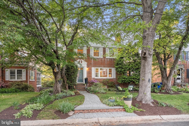 view of front facade with a front yard and brick siding