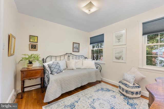 bedroom with baseboards and wood finished floors