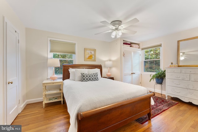 bedroom with wood finished floors, baseboards, and ceiling fan