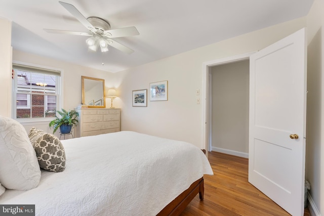 bedroom featuring wood finished floors, baseboards, and ceiling fan