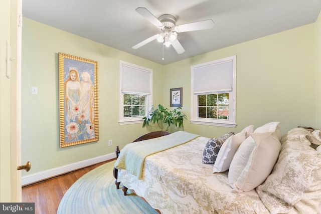 bedroom featuring baseboards, a ceiling fan, and wood finished floors