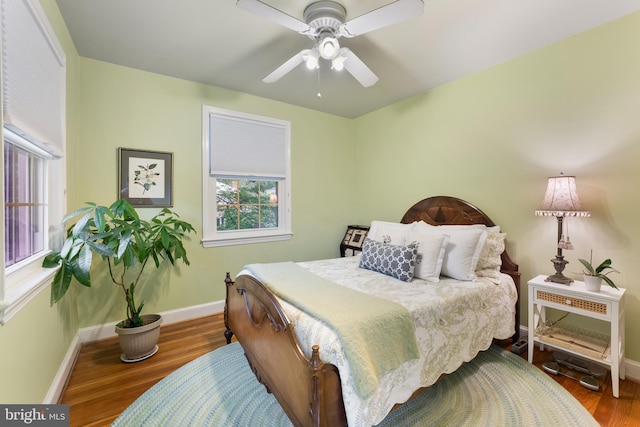 bedroom featuring ceiling fan, baseboards, and wood finished floors