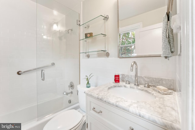 bathroom with toilet, vanity, and enclosed tub / shower combo