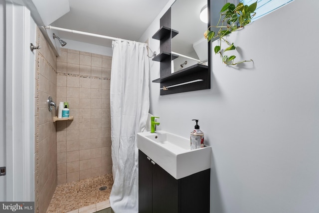 full bath with tiled shower and vanity