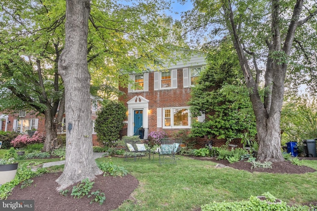 view of front of property with a front yard and brick siding
