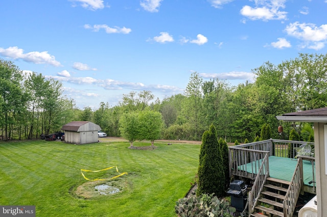 view of yard with an outbuilding, a deck, and a shed