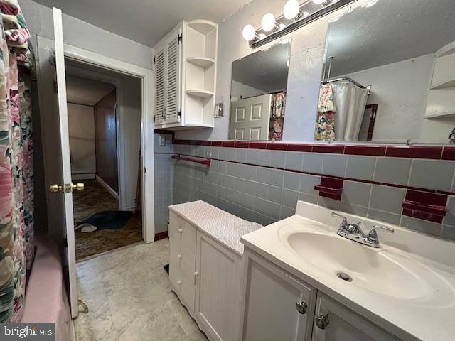 bathroom with vanity and tile walls