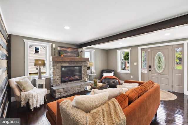 living area with dark wood-style flooring, beamed ceiling, a stone fireplace, baseboards, and recessed lighting