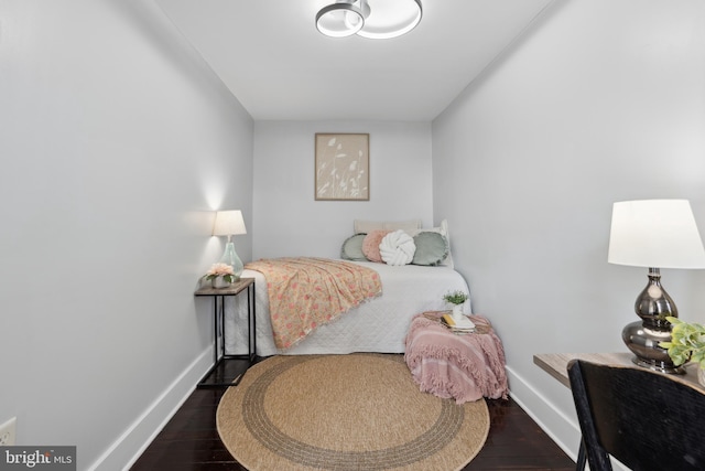bedroom with baseboards and dark wood finished floors