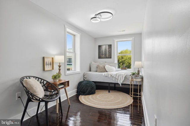 bedroom with baseboards, visible vents, and hardwood / wood-style floors