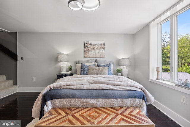 bedroom featuring baseboards and dark wood-style floors