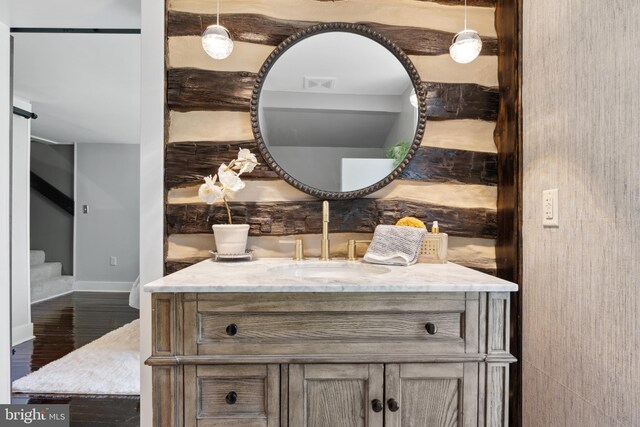 bathroom with baseboards, wood finished floors, visible vents, and vanity