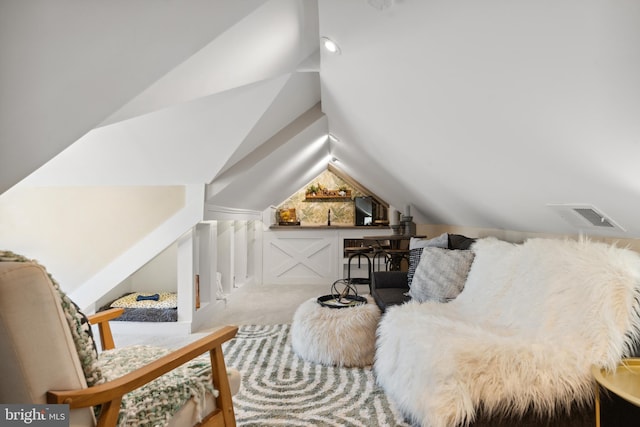 living area with carpet floors, vaulted ceiling, and visible vents