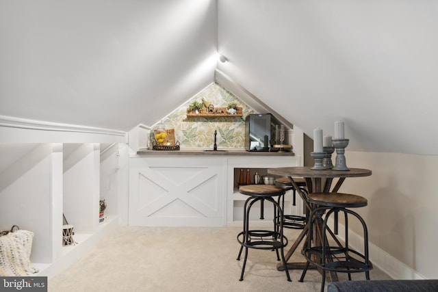 bar with a sink, carpet floors, and vaulted ceiling