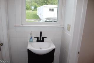 577 Winchester St, Paw Paw, WV 25434 - bathroom with vanity and tile walls